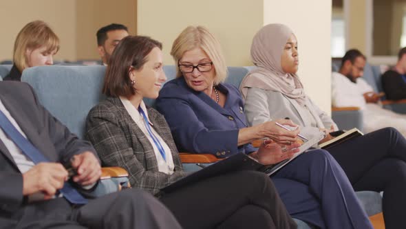 Business People Talking at Conference in Auditorium