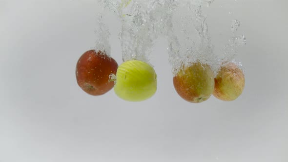 Fresh apples falling into water, Ultra Slow Motion alt