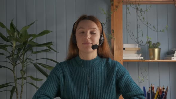 Young Woman in Headset with Microphone Holding Online Meeting