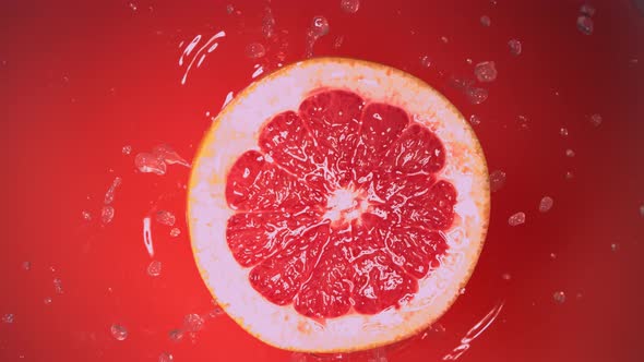 Fresh Half Grapefruit Falling in Juice in Slow Motion