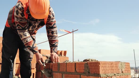 Close Up of a Man Building a Brick House