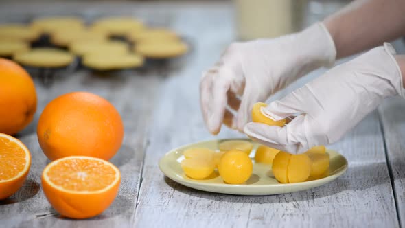 A Pastry Chef in Rubber Gloves Makes Orange Balls. Making Jelly Toppings for the Cake.