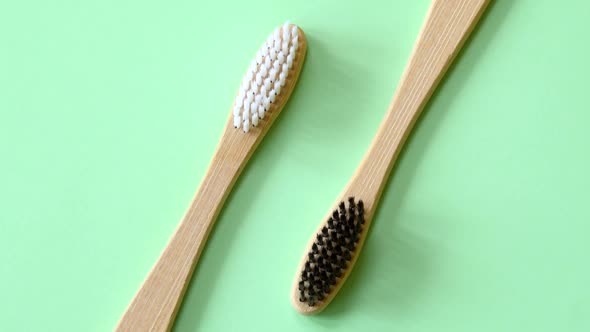 Bamboo Toothbrushes Rotating on Light Green Background