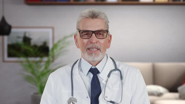 Elderly Male Therapist Looks Into Camera Explains Symptoms of Disease Conducts an Online