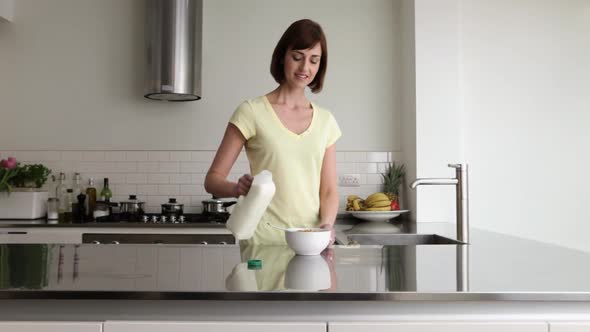 Woman pouring milk onto cereal