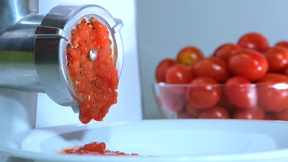 Tomatoes is twisted through a meat Grinder to Prepare Tomato paste