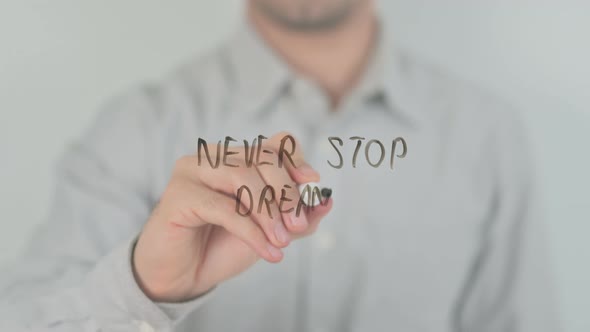 Never Stop Dreaming Writing on Screen with Hand