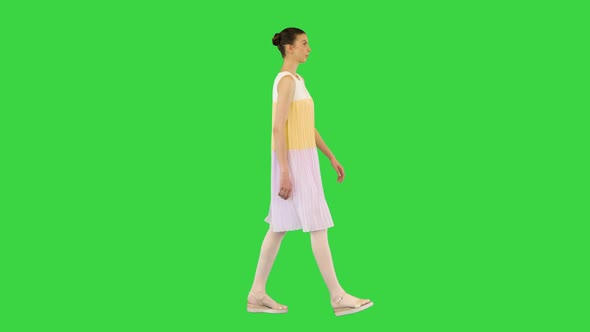 Young Beautiful Girl in Whiteyellow Dress Walks on a Green Screen Chroma Key