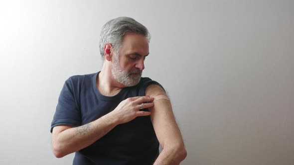 Middleaged Man Showing the Arm Patch After the Vaccination  Immunization Concept