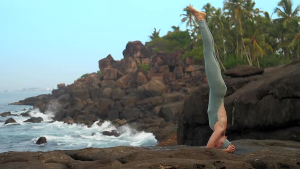 Girl in Gray Bodysuit Shows Sirsasana By Ocean Slow Motion