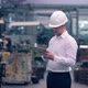 Engineer in Hard Hat is Moving Through a Heavy Industry Factory with a Tablet Computer - VideoHive Item for Sale