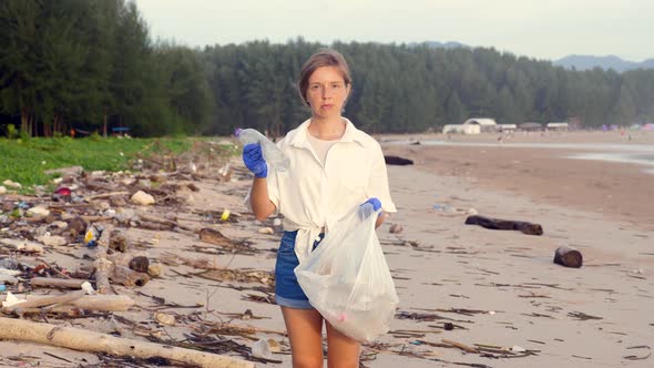 Woman with Trash Bag Clears Beach From Plastic Bottle in Trash Bag