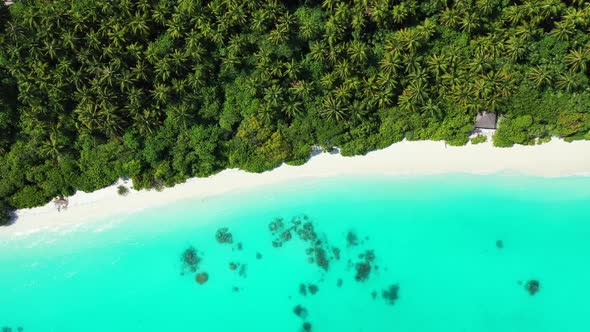 Wide angle overhead tourism shot of a sandy white paradise beach and aqua blue ocean background in c