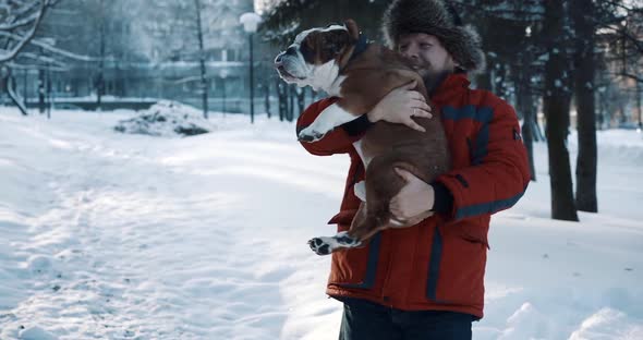 Close Up of Young Bearded Man Hugging and Gently Whirling His Cute Friend English Bulldog