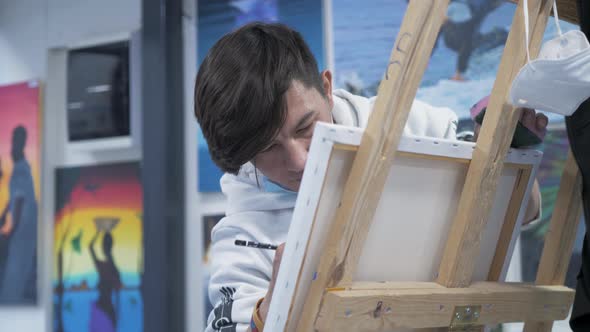 Young talented Afghan painter working in art studio