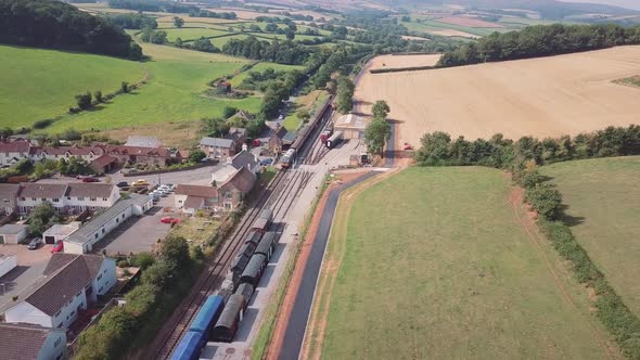 Drine tracking sideways from right to left over Washford train station and the village of Washford,