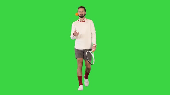 Sporty Tennis Player Walking with a Ball in His Hand on a Green Screen Chroma Key