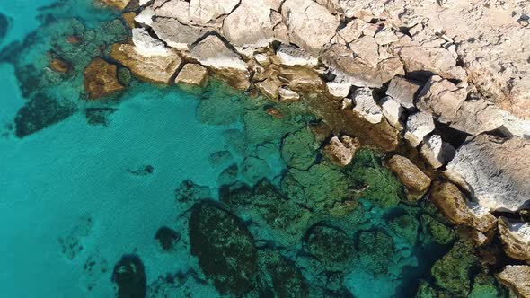 Rocky Cliff on the Seashore Aerial Top View Footage By Drone of Ocean Blue Water and Rocks Edge of