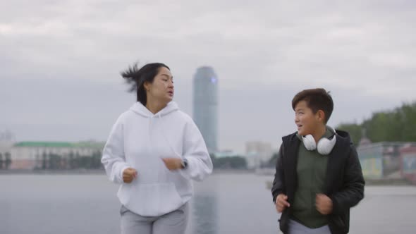 Asian Boy Running with Mom in the Morning