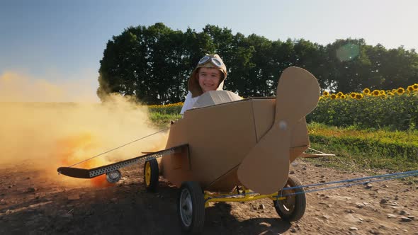 Happy Little Boy Driving a Cardboard Plane with Smoke