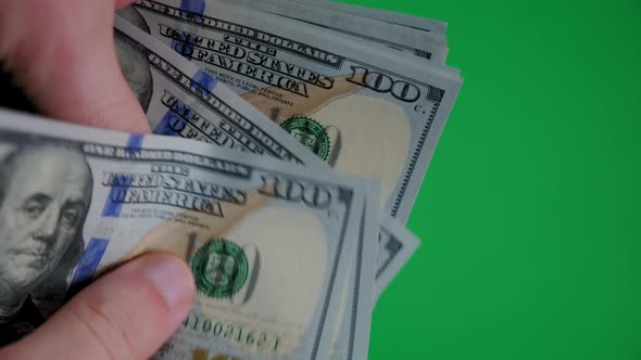 Count of Money From Hand to Hand on a Green Background