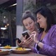 Two Cheerful Girlfriends Showing Each Other Something Funny in Their Phones During Lunch. Enjoying - VideoHive Item for Sale