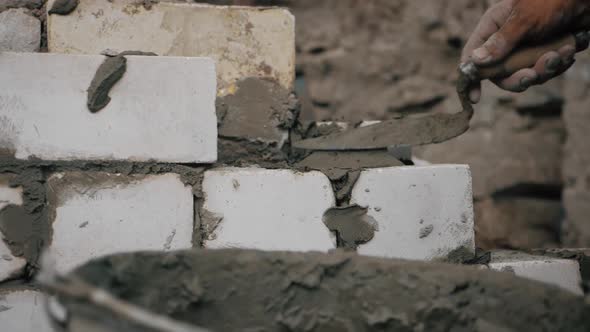 Construction Worker or Mason Laying Bricks and Creating Walls. Bricklayer Laying Bricks To Make a alt