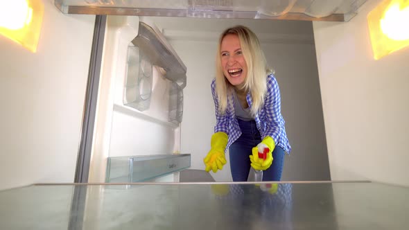 A woman looks inside the refrigerator and screams. Stress. cleaning.