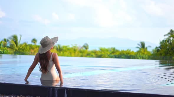 Young asian woman enjoy around outdoor swimming pool for leisure