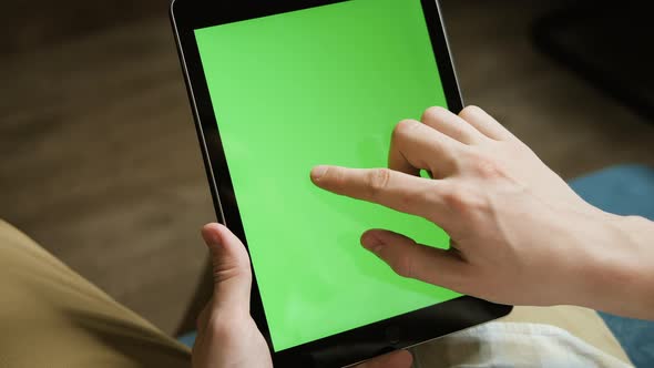 A Mockup of a Man Holds a Tablet Computer with Chroma Key Screen in His Hands