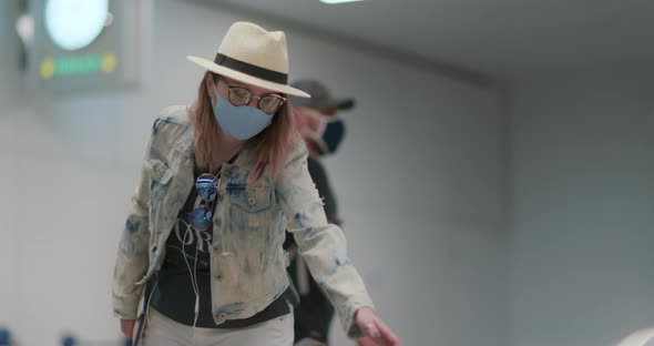 Traveler in Face Mask at the Arrival Area of Empty Airport During COVID19