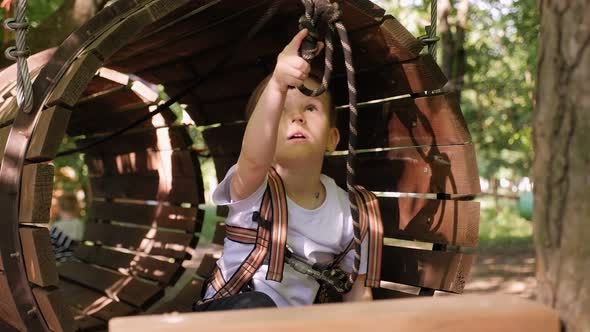 Little Boy Who Climbs on a Rope the Way to the Amusement Park in the Summer