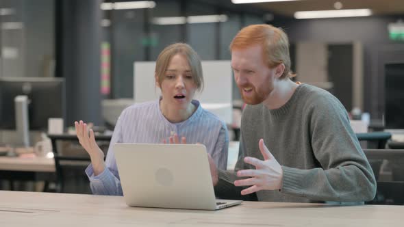 Young Man and Woman Reacting to Loss on Laptop