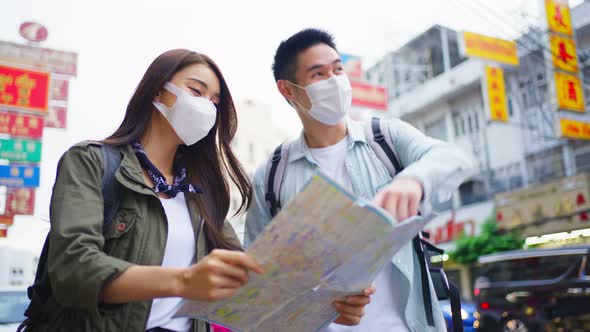 Young new marriage man and woman backpacker tourist wear mask travel in the city for honeymoon trip