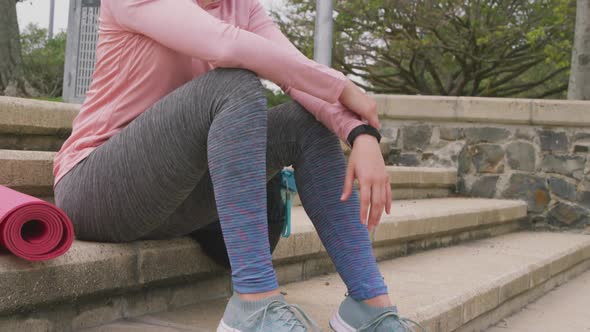 Caucasian woman sitting with a yoga mat