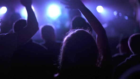 Silhouette of a Girl Dancing at a Rock Band Concert