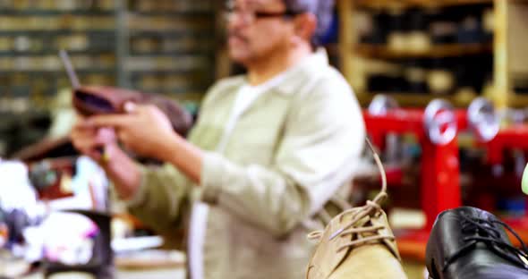 Cobbler examining a shoe