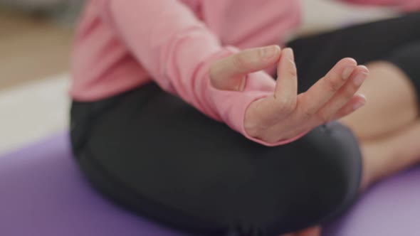 Close Up hands a beautiful caucasian female meditating in a lotus position in quarantine at home.