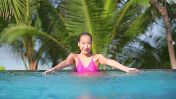 Young asian woman enjoy around outdoor swimming pool for leisure