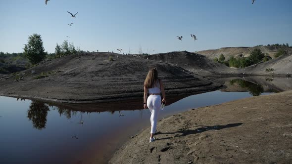 Sports Girl with a Beautiful Figure in Sports Uniform Walks Along the Shore