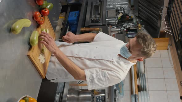 Chef In Mask Cutting Zucchini