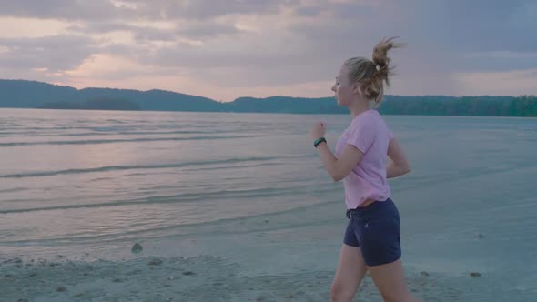 Woman Jogging By the Ocean Beach