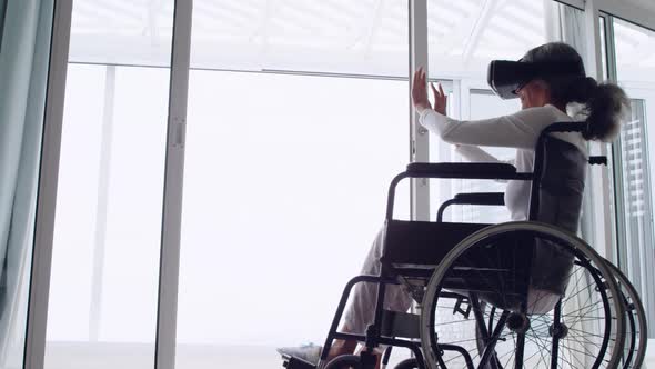 Mature woman in a wheelchair using VR