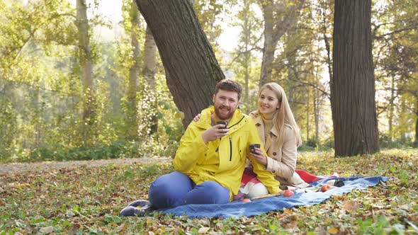 Young Married Couple Drinking Tea Coffee Sitting Lawn During Romantic Picnic Autumn Park