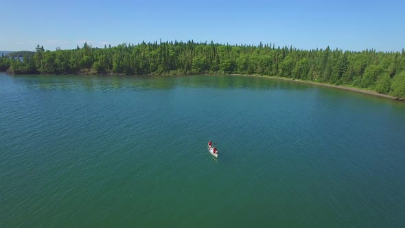 People Canoeing On Lake With Island Aerial