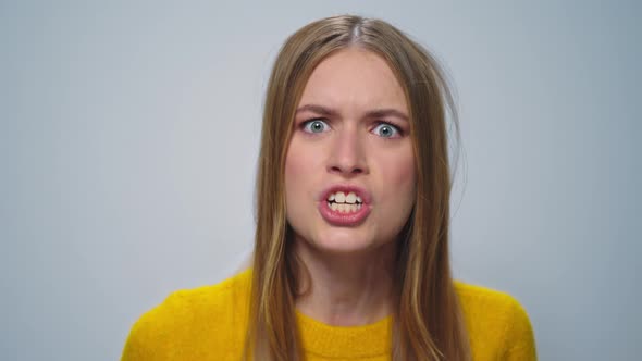 Portrait of Angry Woman Screaming with Aggressive Emotion at Camera in Studio