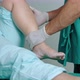 orthopedist examining the knee of an elderly woman lying in a hospital bed - VideoHive Item for Sale