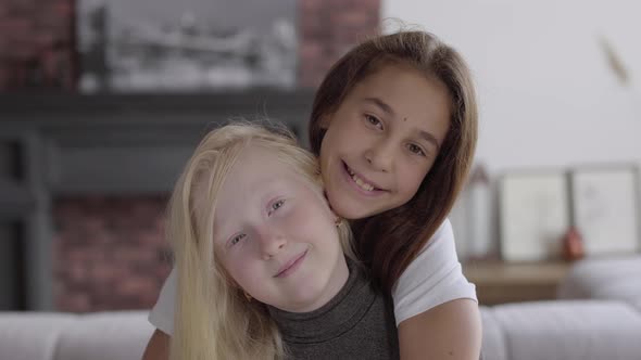 Portrait Adorable Little Albino Girl Hugging Her Girlfriend Looking at Camera Smiling