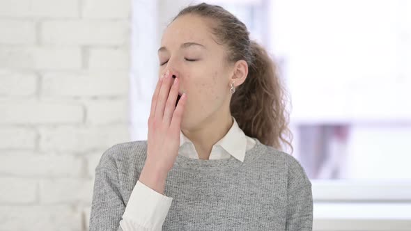 Portrait of Sleepy Young Latin Woman Yawning 