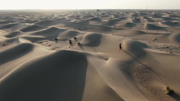 High Angle View on a Woman Walking on Sand Dunes in Rub Al Khali Desert